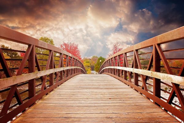 Long wooden walkway bridging the gap to the brighter side.