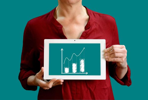 Woman displaying a business growth chart on a tablet screen.